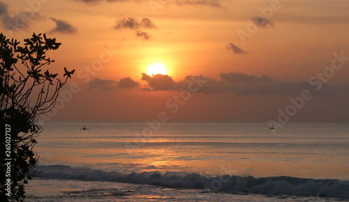 Bali beach sunset with fishing boats and bright sky