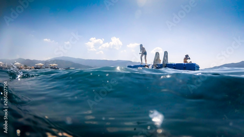 Image of happy children jumping from floating pantoon at sea photo