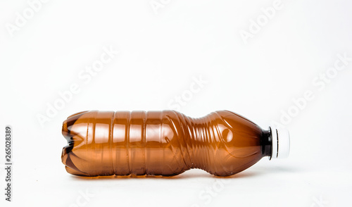 A plastic brown bottle on a white background. Concept of caring for the environment, recycling. Secondary plastic circuit. Environment pollution.