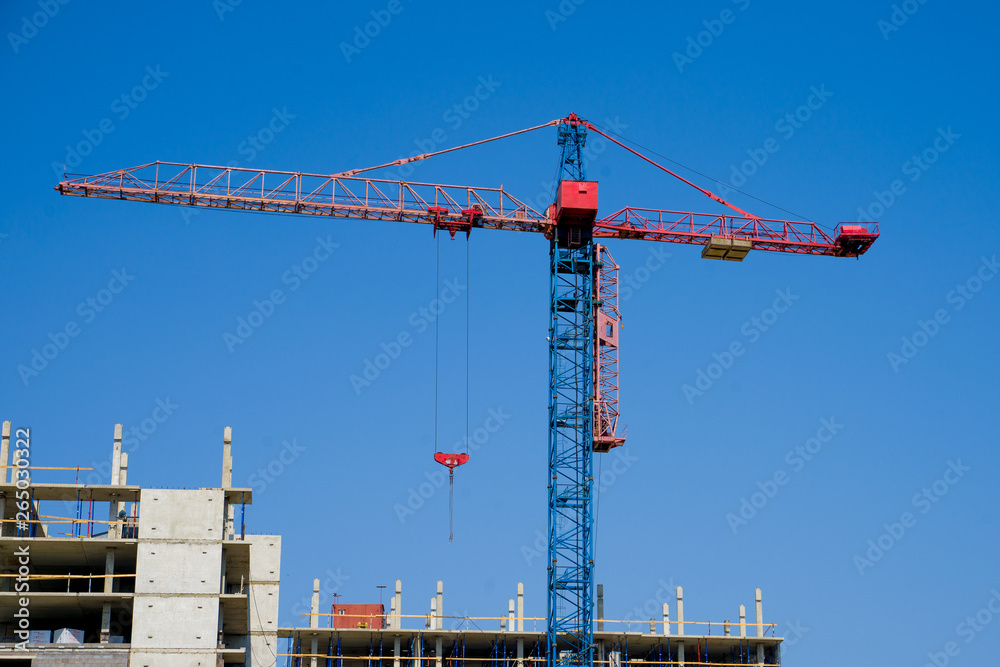 Construction crane on the background of a multi-storey building under construction