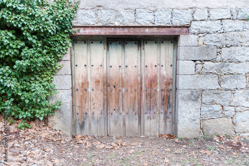 Old wooden door belonging to housing located in country village.