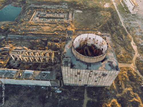 Abandoned and ruined Nuclear Power Plant in Shelkino, Crimea. Industrial construction with round tower of atomic reactor, aerial view photo