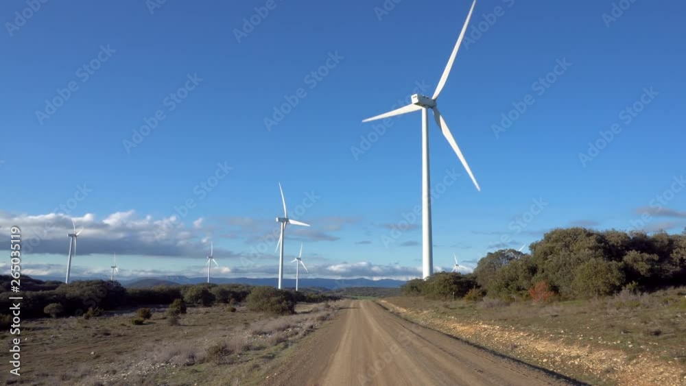 Pov walking toward large wind turbine on a sunny day . Pov walking toward large wind turbine on a sunny day .