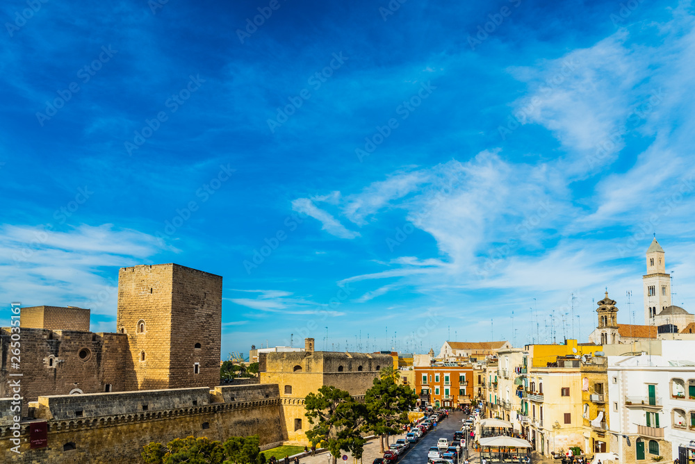 Bari, Italy - March 10, 2019: View of the Svevo castle and the square of Federico II di Svevia a spring day with a background of blue sky and clouds.