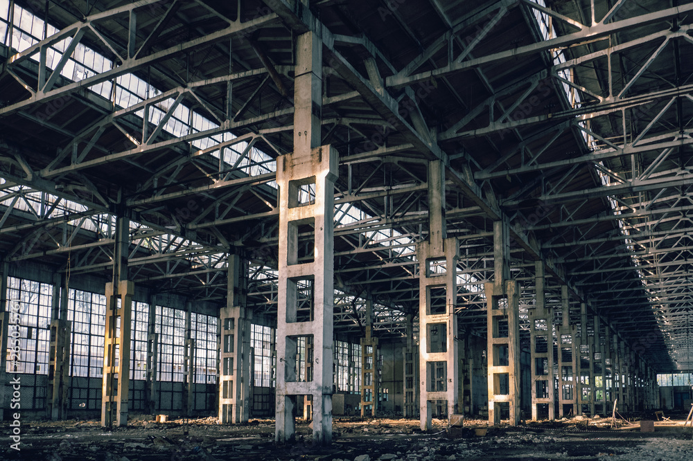 Ruined industrial hall of warehouse or hangar, creepy and old construction