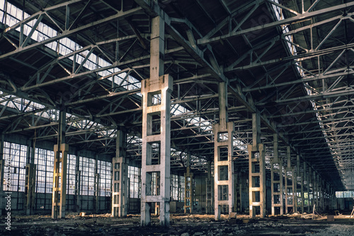 Ruined industrial hall of warehouse or hangar, creepy and old construction