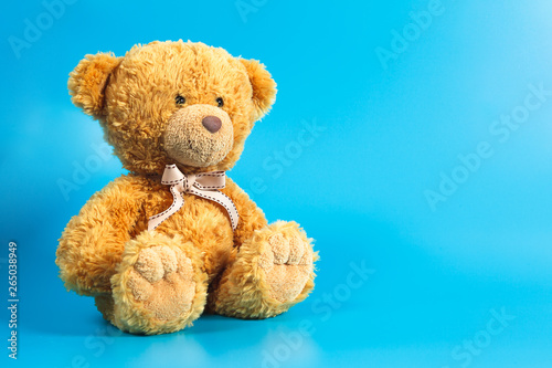 Soft warm cute brown teddy bear on color background. Isolated. Soft blue background. Copy spasespace for text.