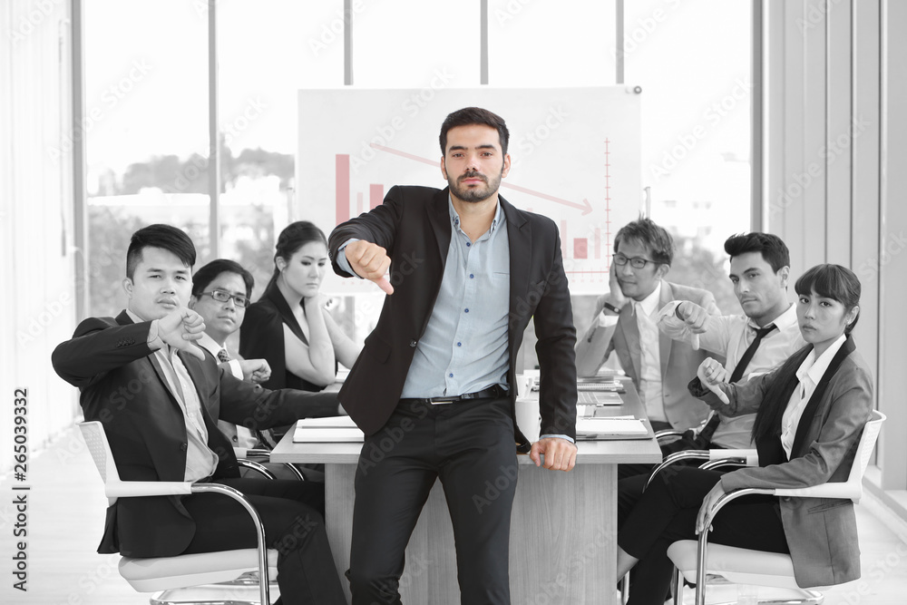 caucasian boss businessman showing thumb down or dislike with unhappy face with unsuccess multiethnic business team and business graph background caucasian boss businessman showing thumb down or dislike with unhappy face with unsuccess multiethnic business team and business graph background
