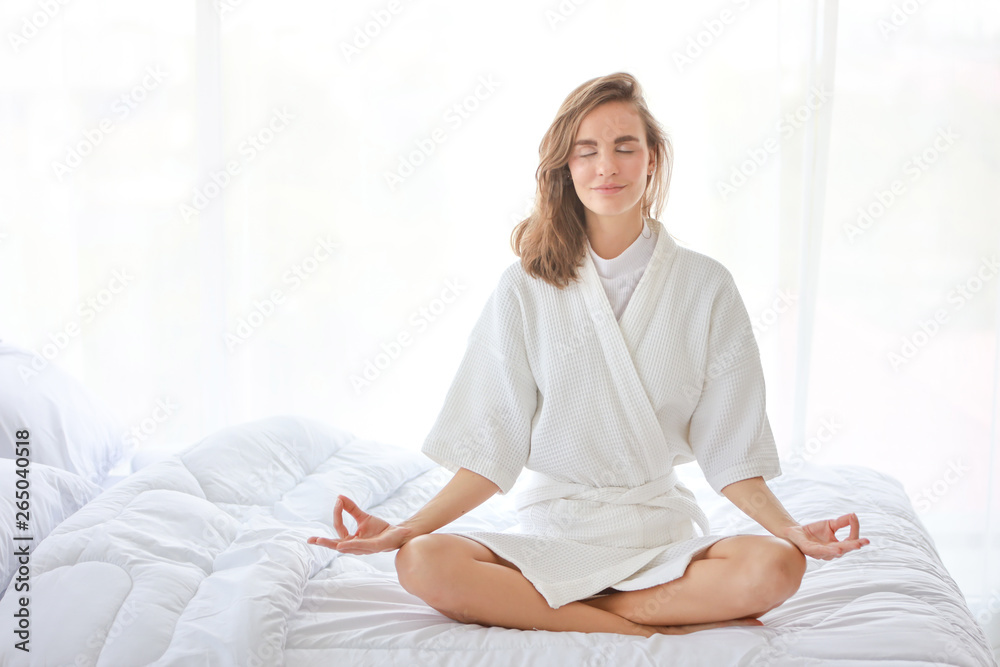 young and beautiful caucasian girl enjoying in meditates with yoga pose on bed in bedroom with happy and smile face young and beautiful caucasian girl enjoying in meditates with yoga pose on bed in bedroom with happy and smile face