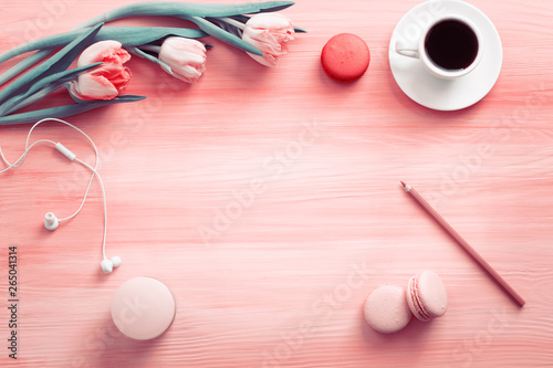 Fototapeta Naklejka Na Ścianę i Meble -  Morning cup of coffee, cake macaron and flower on light pink table from above. Beautiful breakfast. Flat lay style.