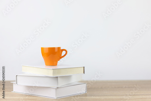 coffee cup with books on wooden desk and white background