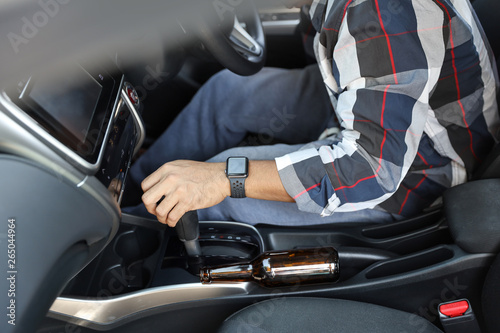 drunk man falling as sleep while driving a car with alcohol bottle beside (drink not drive concept)