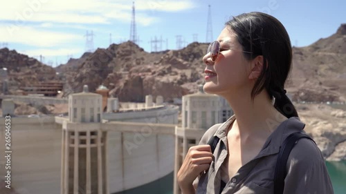 happy asian woman tourist sightseeing outdoor view of Hoover Dam Arizona USA of Lake Mead and the water intake towers. young girl traveler hiking desert mountain in summer vacation holiday self.