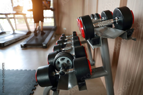 Fototapeta Naklejka Na Ścianę i Meble -  dumbell set on the rack in fitness gym with sunlight effect