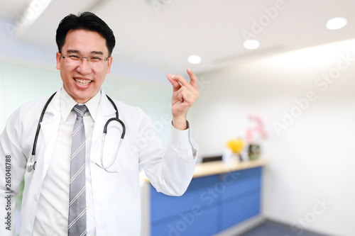 male doctor snap finger with bluerred clinic background (meaning somthing very easy) photo