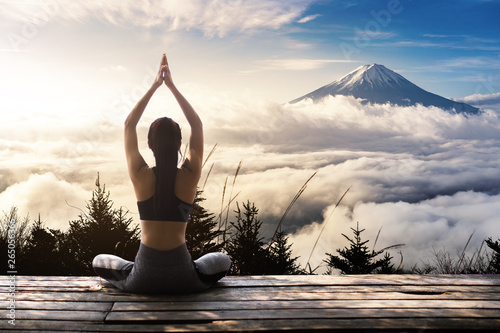 Young woman practicing yoga in the nature. female happiness. Landscape background.
