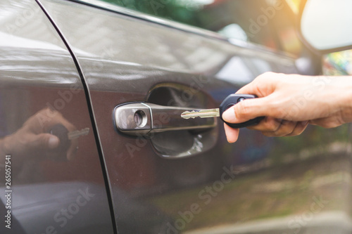 Closeup hand woman holding key opening car door.