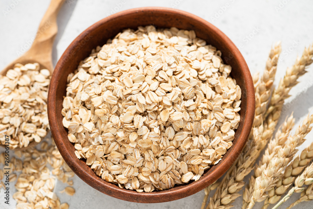 Oats, oat flakes or rolled oats in a bowl. Closeup view. Healthy clean eating food, healthy lifestyle concept Oats, oat flakes or rolled oats in a bowl. Closeup view. Healthy clean eating food, healthy lifestyle concept