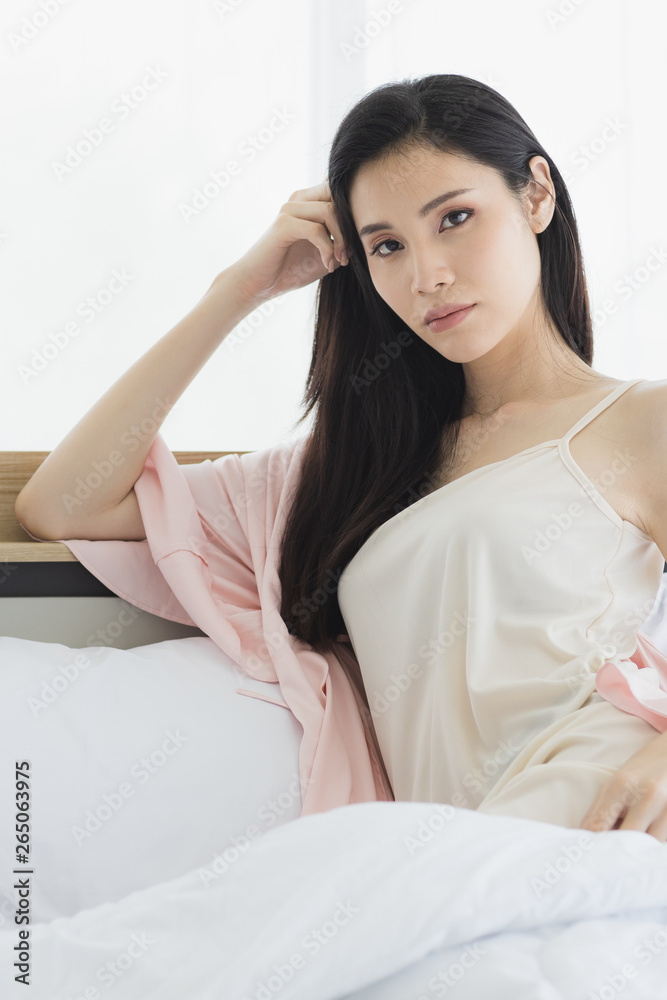 Asian woman model sitting and posing on bed.. Asian woman model sitting and posing on bed..