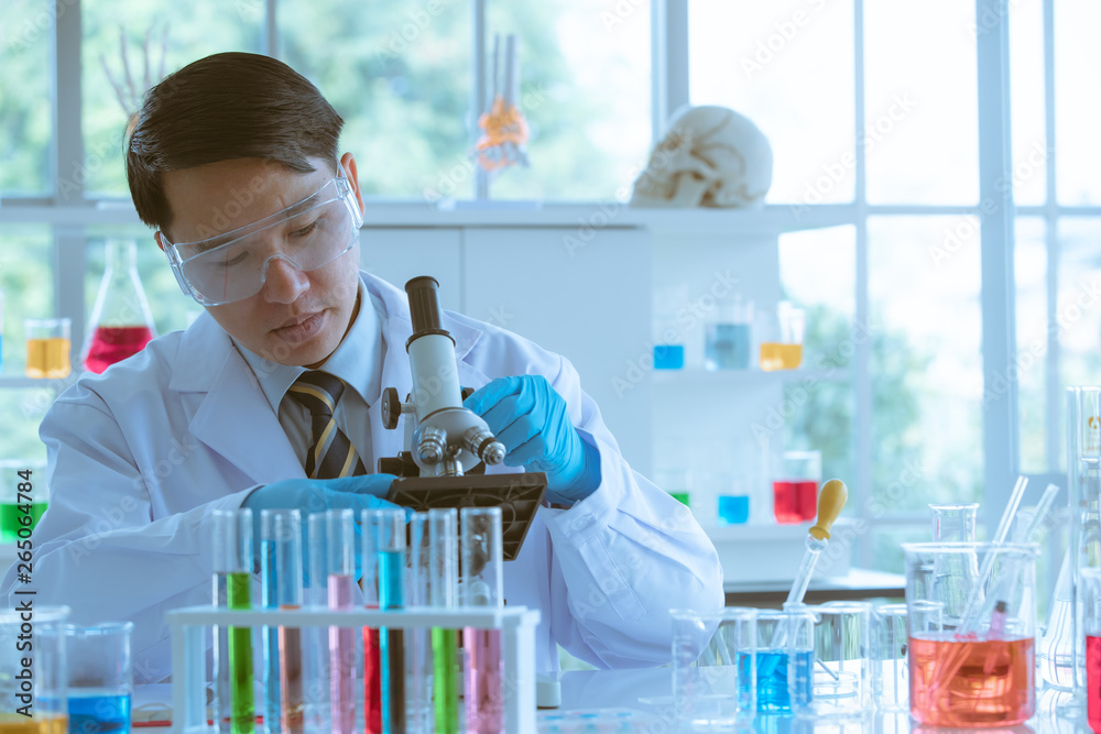 Scientist adjusting microscope for experiment. Scientist adjusting microscope for experiment.