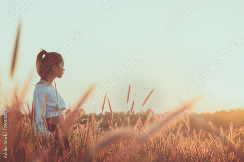 Beautiful young asian woman in a field with sunlight