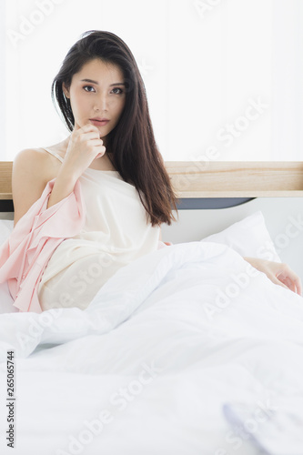  Asian woman model sitting and posing on bed.. © Bangkok Click Studio