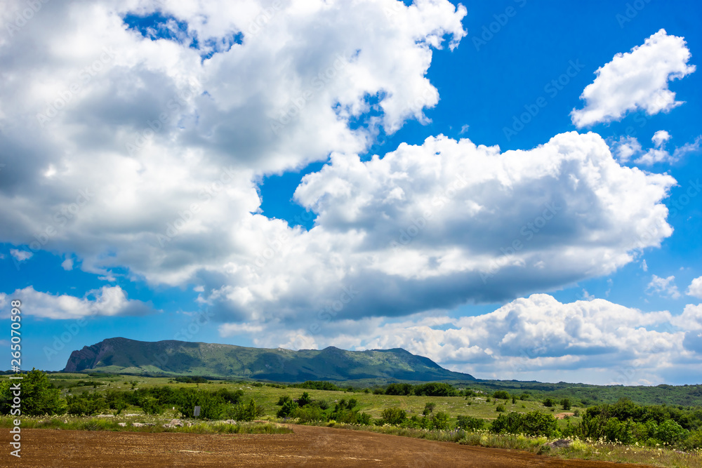 Colorful summer landscape in the Crimean mountains, under a blue sky with white clouds Colorful summer landscape in the Crimean mountains, under a blue sky with white clouds