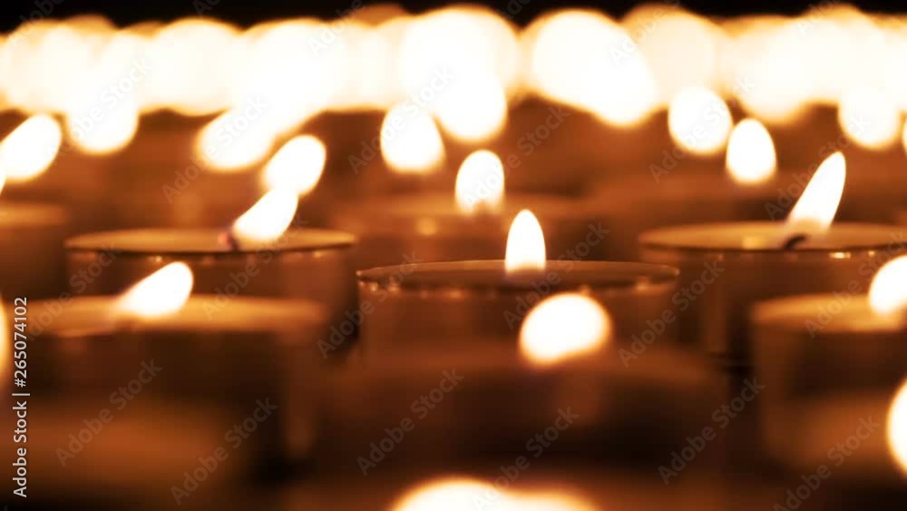 Extinguished Lights Candles Are Slowly Extinguished. A large field of lit small candles on ...