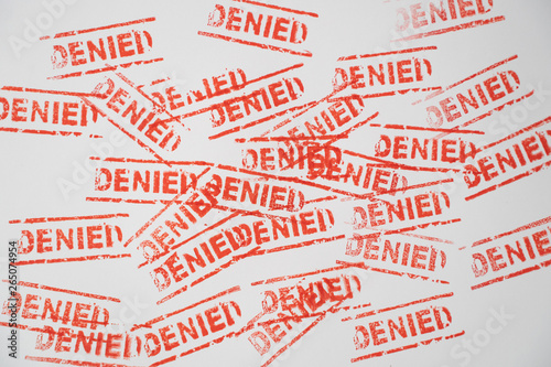 denied word stamp on white paper with red ink