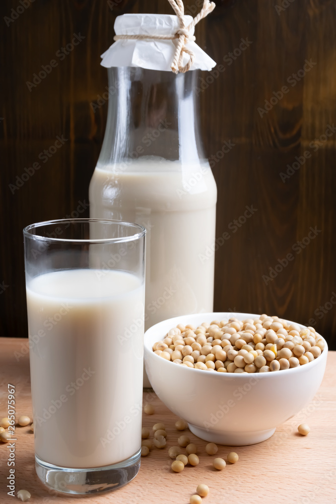 Glass of Soy milk and bottle and organic soy seeds on wooden background, Alternative Milk Glass of Soy milk and bottle and organic soy seeds on wooden background, Alternative Milk