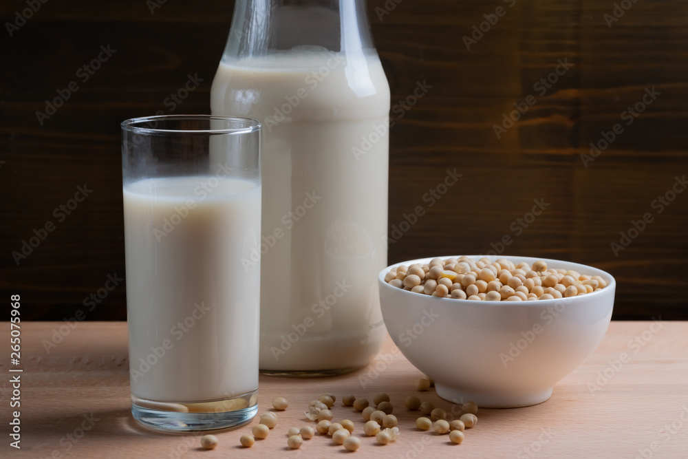 Glass of Soy milk and bottle and organic soy seeds on wooden background, Alternative Milk Glass of Soy milk and bottle and organic soy seeds on wooden background, Alternative Milk