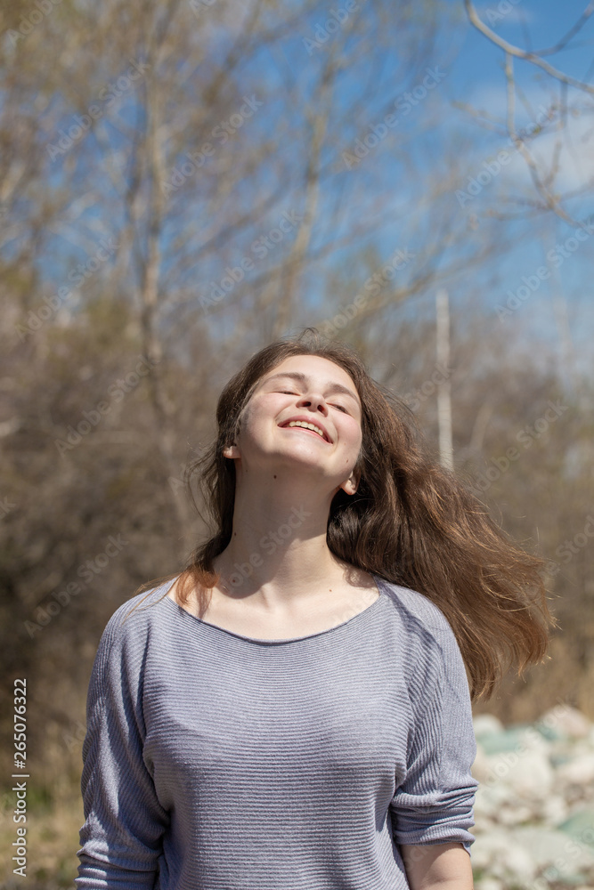 Young girl on nature with positive emotions. Relaxed, pleased with a smile on her face. Twists his head. Carefree fun pastime. Young girl on nature with positive emotions. Relaxed, pleased with a smile on her face. Twists his head. Carefree fun pastime.