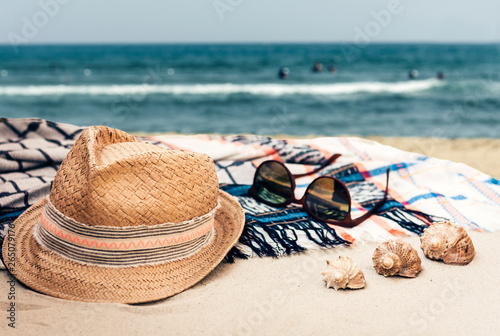 Straw hat  sun glasses and cover-up beachwear wrap on a tropical beach .