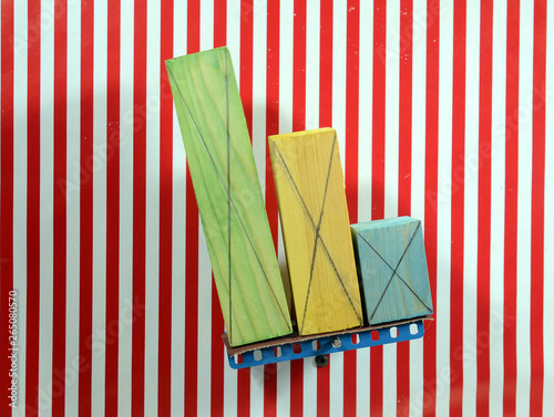 Colorful wood blocks of different size placed on a board that tgradually tilts, one by one they fall. The background lines are vertical reference (series of 4) photo