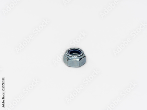 Zinc plated self locking hexagonal metric stop nut on white.