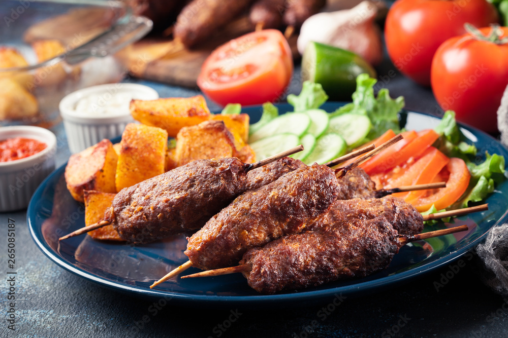 Grilled shish kebab served with fried potatoes