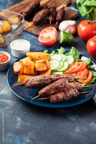 Grilled shish kebab served with fried potatoes