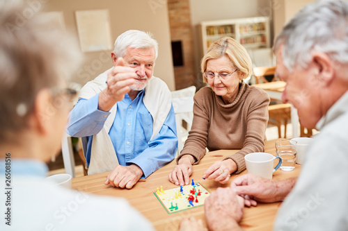 Rentner Paar spielt mit Freunden Brettspiel