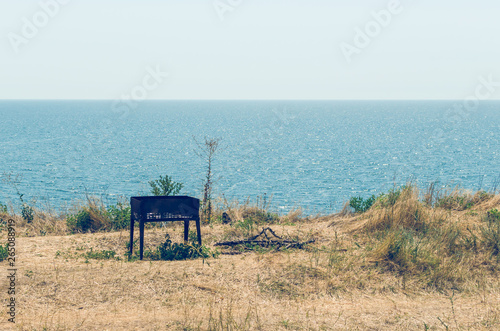 Old brazier on the sea left after a picnic