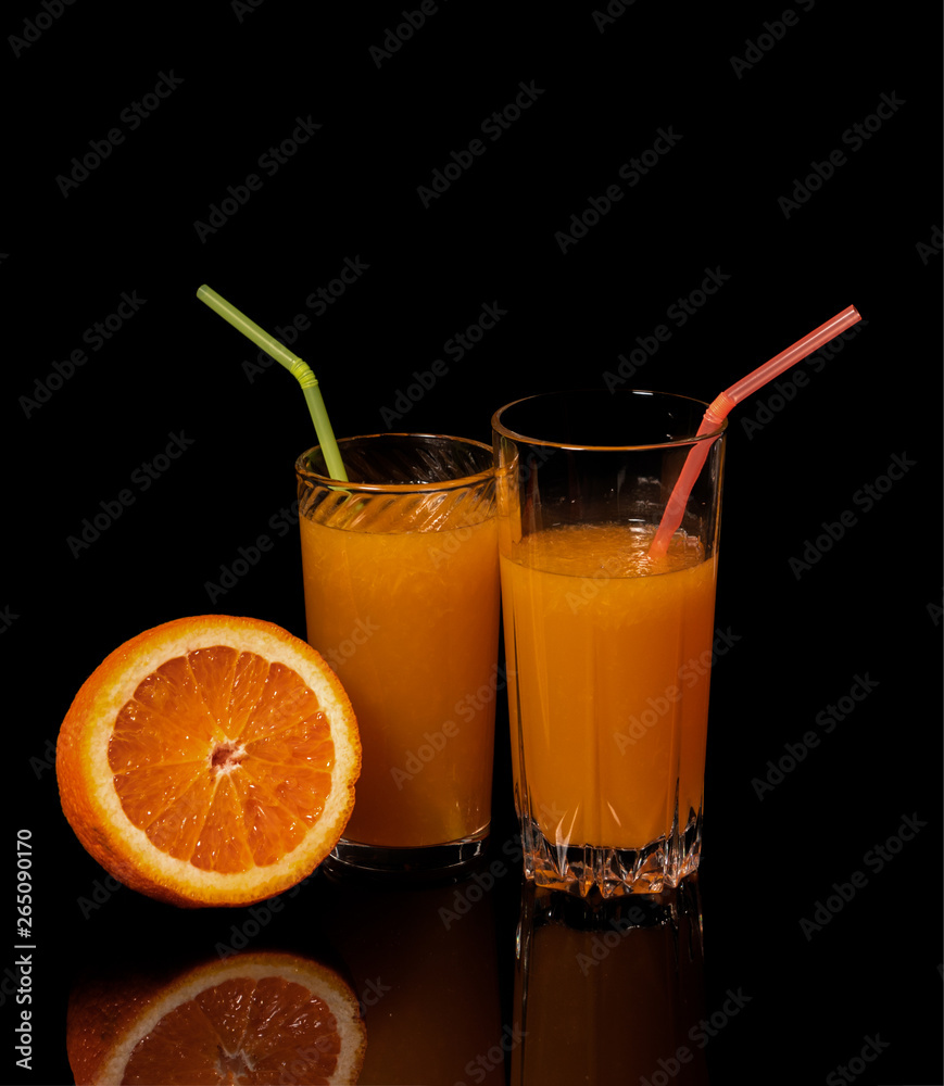 Glass with fresh orange juice and orange on a black background Glass with fresh orange juice and orange on a black background