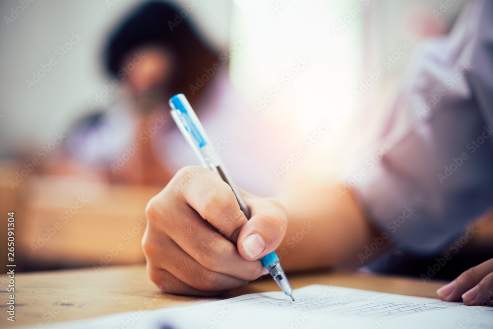 Hand of students writing and taking exam with stress in classroom Hand of students writing and taking exam with stress in classroom