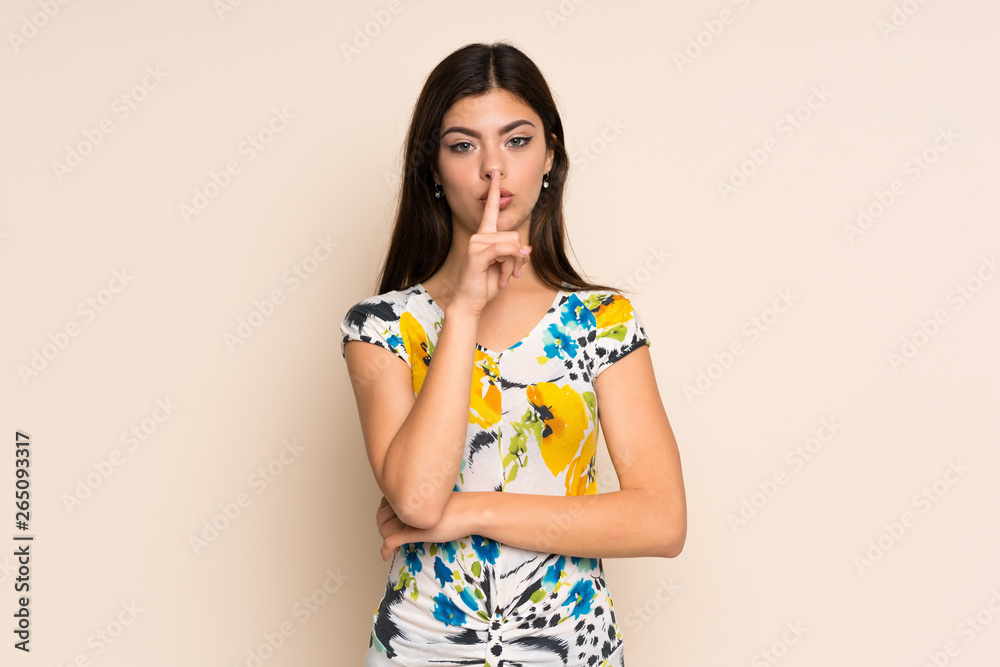 Teenager girl with floral dress showing a sign of silence gesture putting finger in mouth