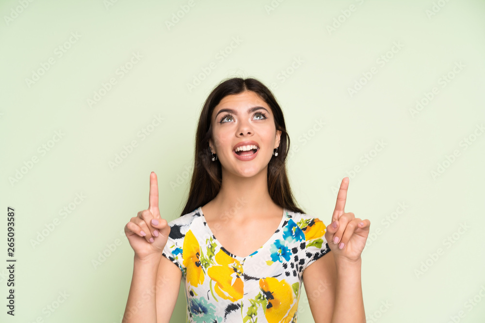 Teenager girl with floral dress pointing with the index finger a great idea Teenager girl with floral dress pointing with the index finger a great idea