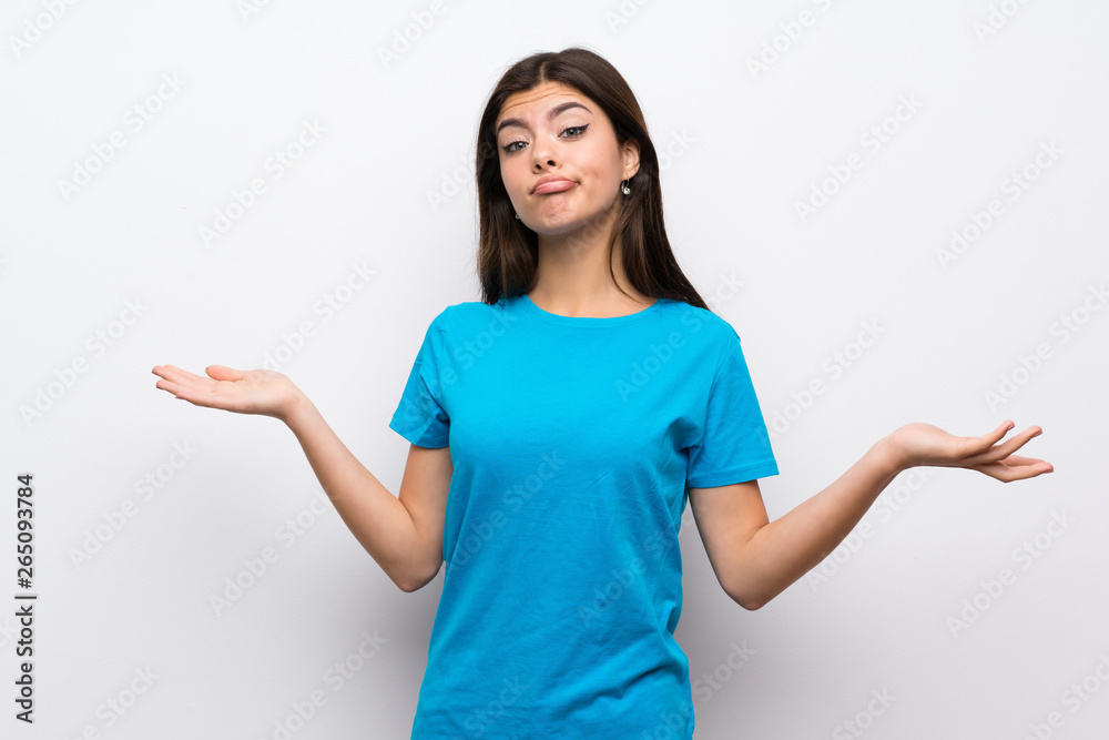 Teenager girl with blue shirt having doubts while raising hands Teenager girl with blue shirt having doubts while raising hands