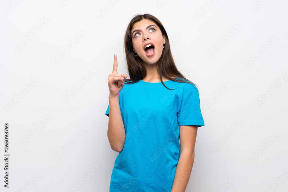 Teenager girl with blue shirt pointing up and surprised Teenager girl with blue shirt pointing up and surprised