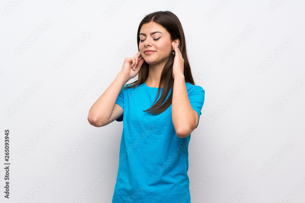 Teenager girl with blue shirt frustrated and covering ears Teenager girl with blue shirt frustrated and covering ears