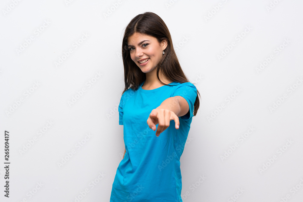 Teenager girl with blue shirt points finger at you with a confident expression