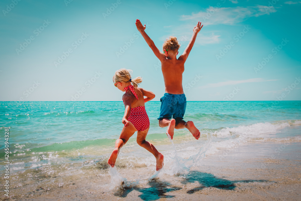 happy little boy and girl play on beach happy little boy and girl play on beach