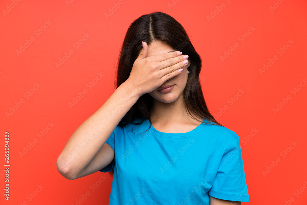 Teenager girl with blue shirt covering eyes by hands Teenager girl with blue shirt covering eyes by hands