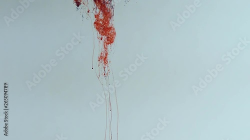 Falling and slowly mixing red and blue paint in water,
